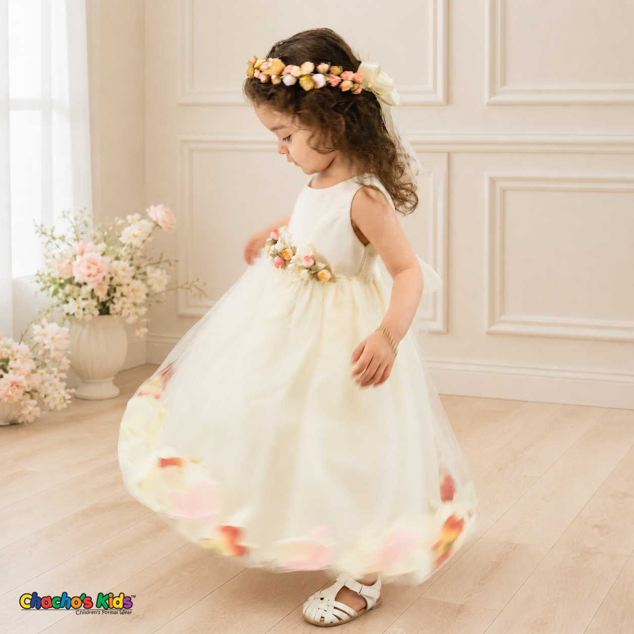 Side twirl view of ivory D1095 baby flower girl dress with floral waist and petal-filled tulle skirt