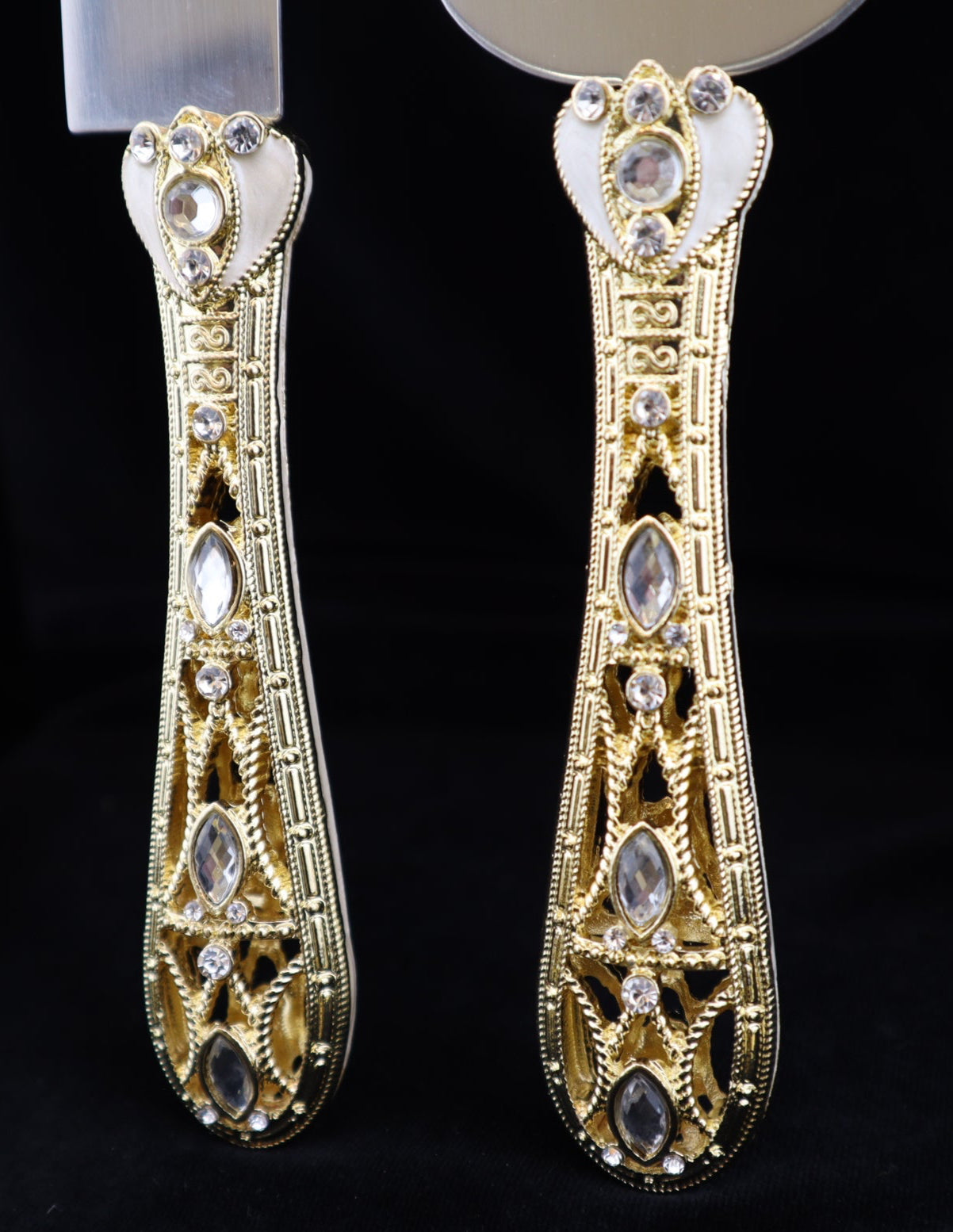 Pair of gold earrings with intricate designs on a black background