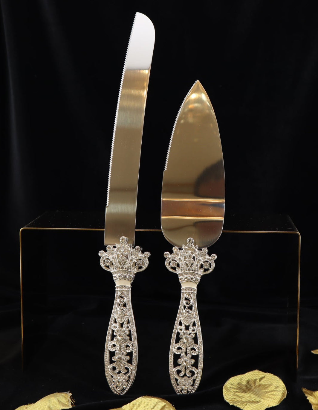 Gold cake knife and server set on a black background with decorative elements.
