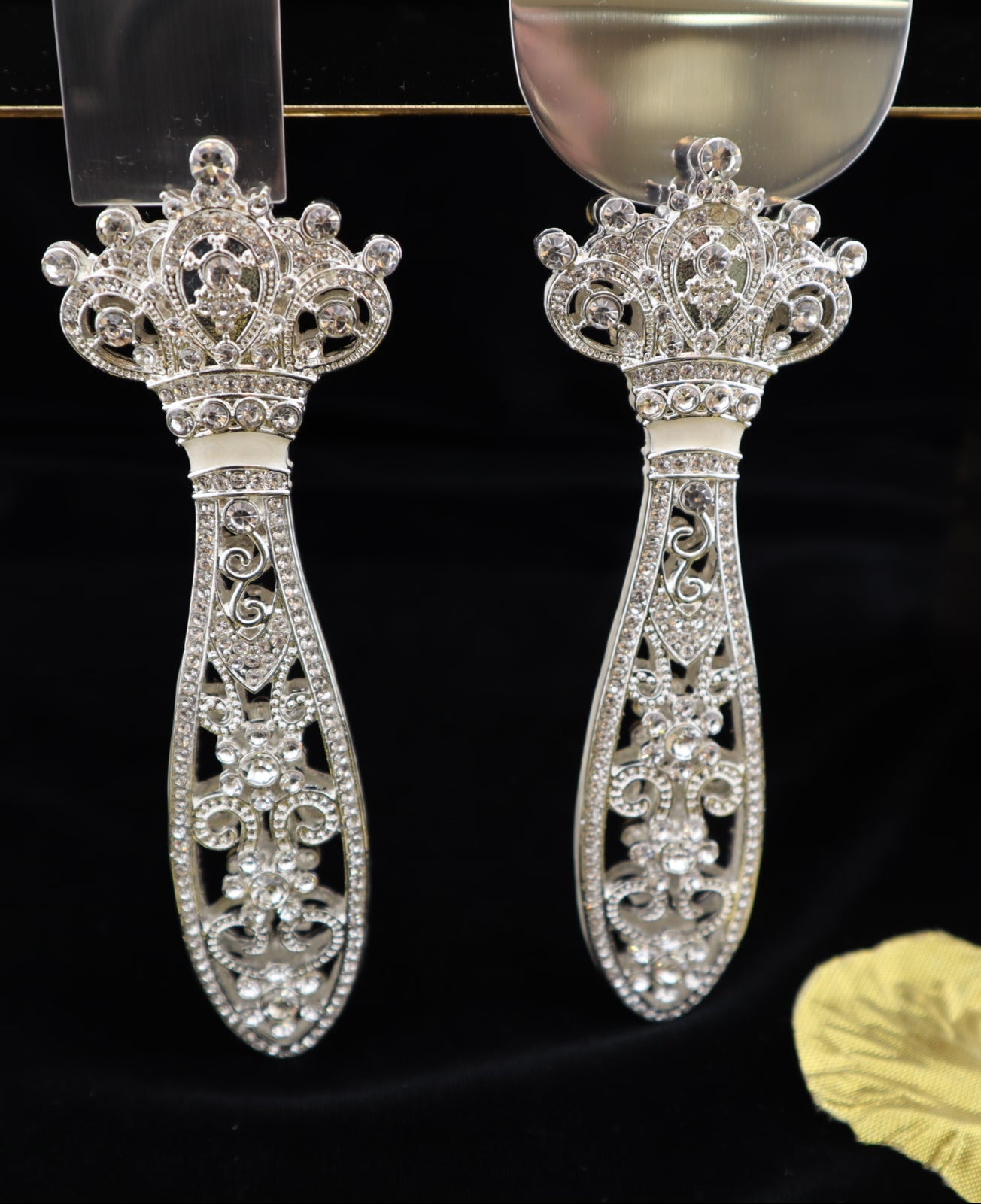 Decorative silver cake server set on a black background with gold leaves.