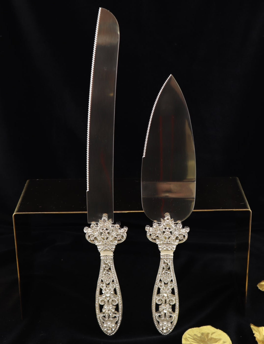Set of silver cake knives with decorative handles on a black background