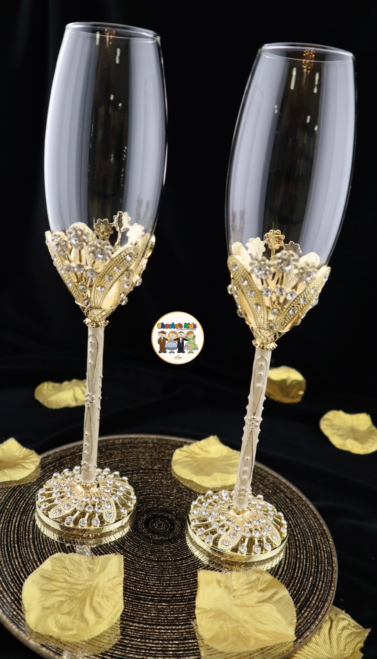 Two ornate Wedding champagne flutes with gold and crystal detailing on a black background.