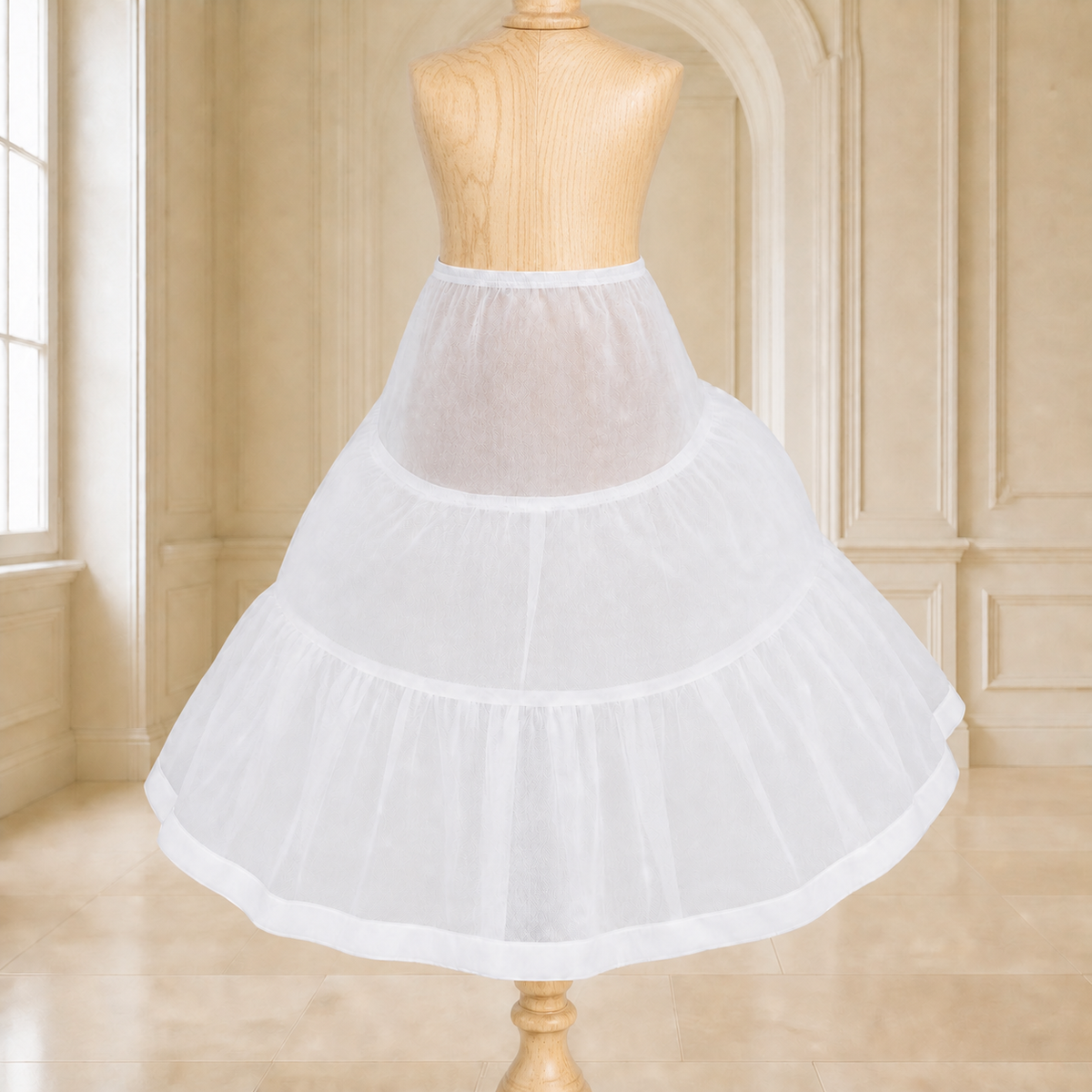 White girls' petticoat displayed on a light natural-wood mannequin in an elegant cream interior