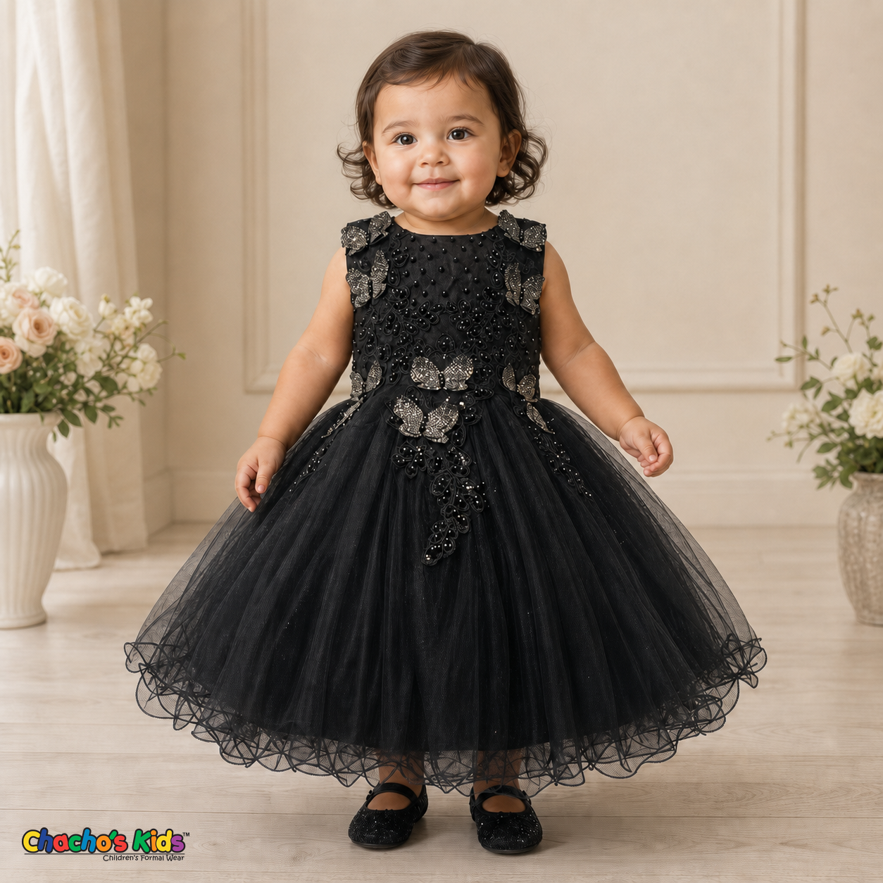Black baby flower girl dress 9156B with butterfly embroidery, pearl details, layered tulle skirt, and no head accessory on a realistic toddler model