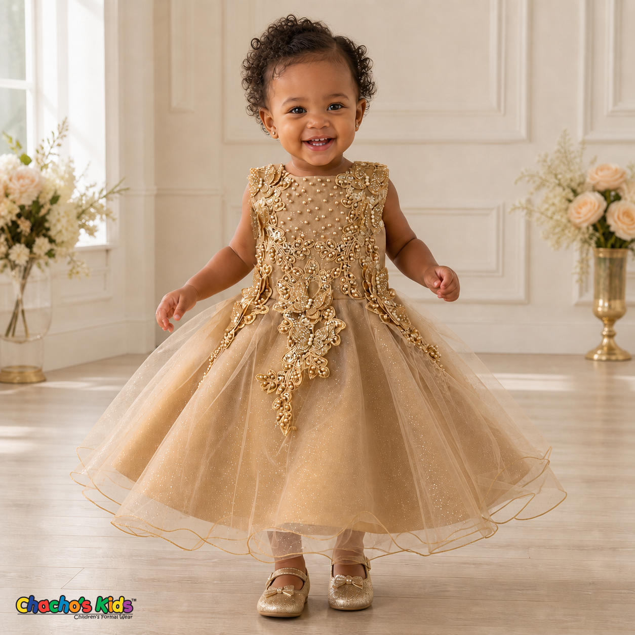 Gold baby flower girl dress 9156B with butterfly embroidery, pearl details, layered glitter tulle skirt, and no head accessory on a realistic toddler model