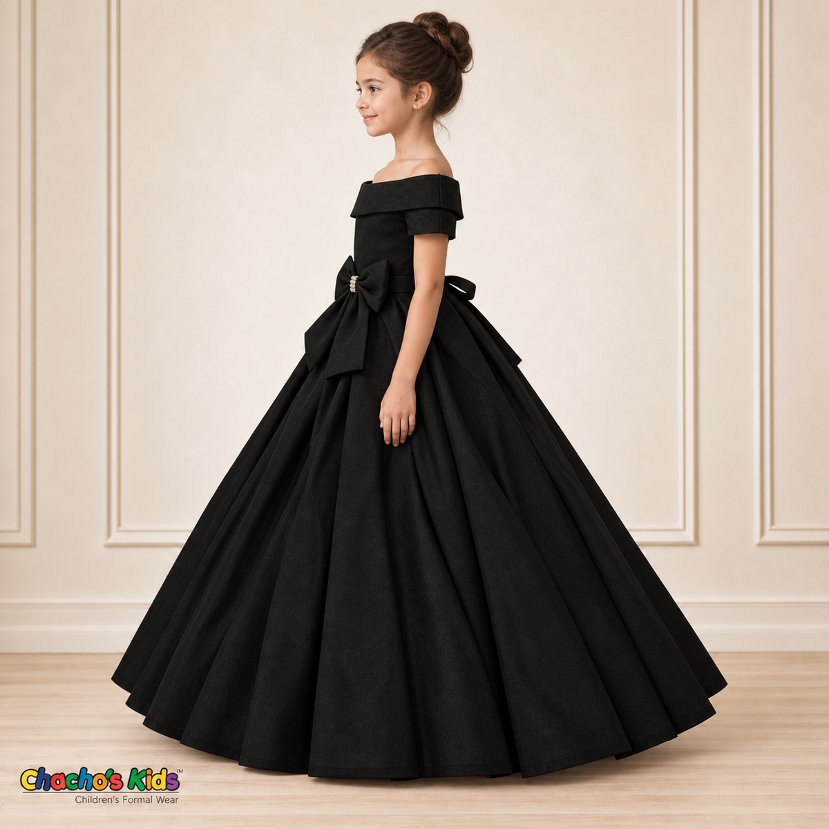 Black ball gown dress, style 9177, left-facing side view on a child model with a folded neckline, jeweled waist bow and full floor-length skirt.
