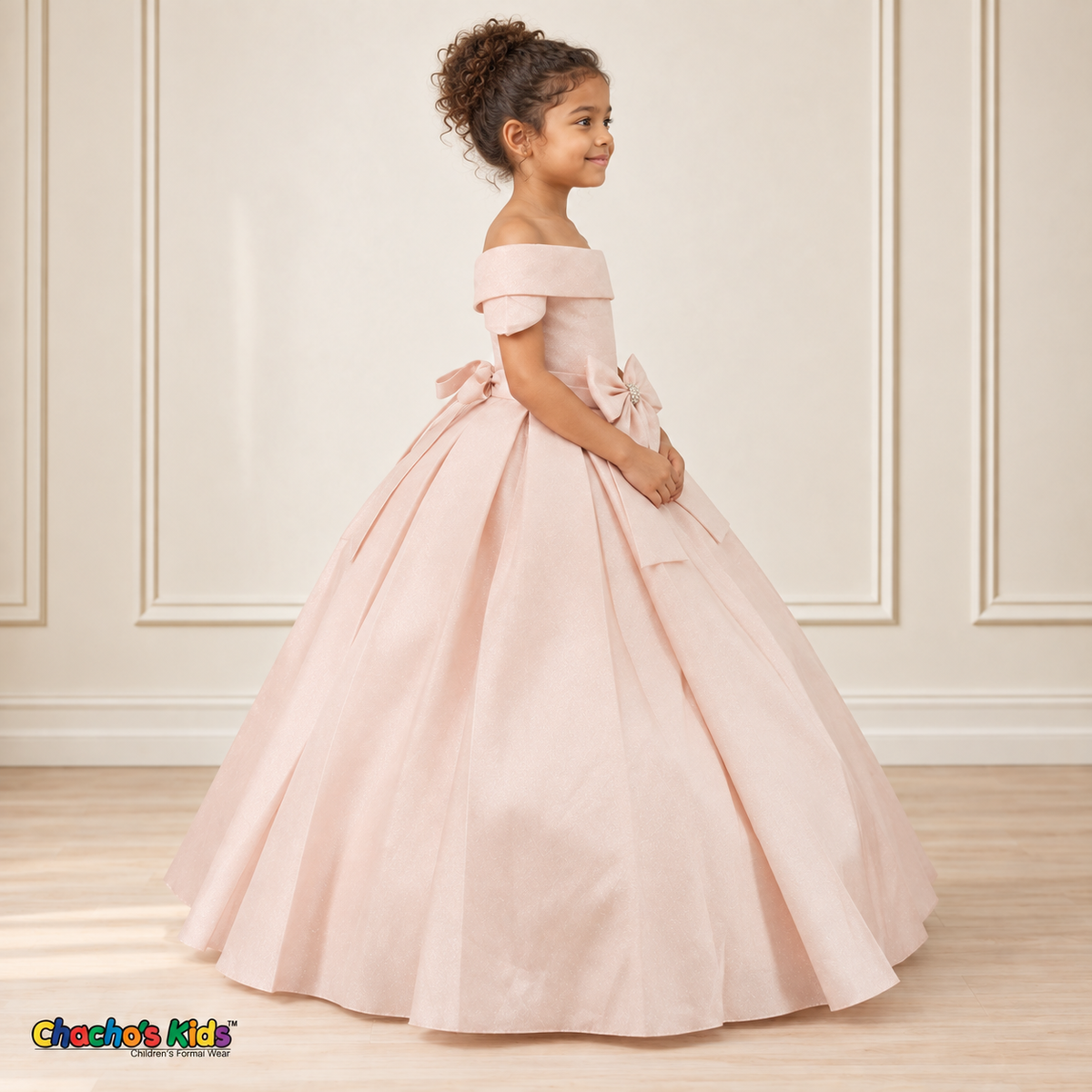 Blush ball gown dress, style 9177, right-facing side view on a child model with a folded neckline, jeweled waist bow and full floor-length skirt.