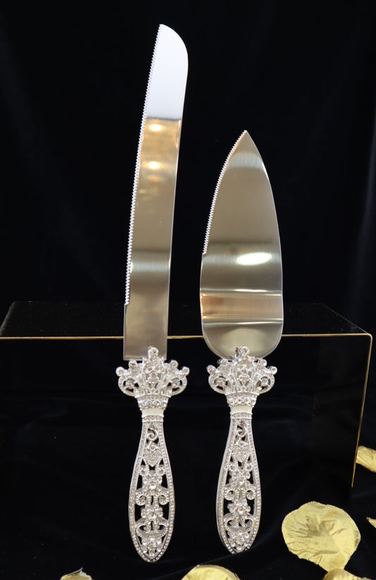 Silver cake server and knife set with decorative handles on a black stand.