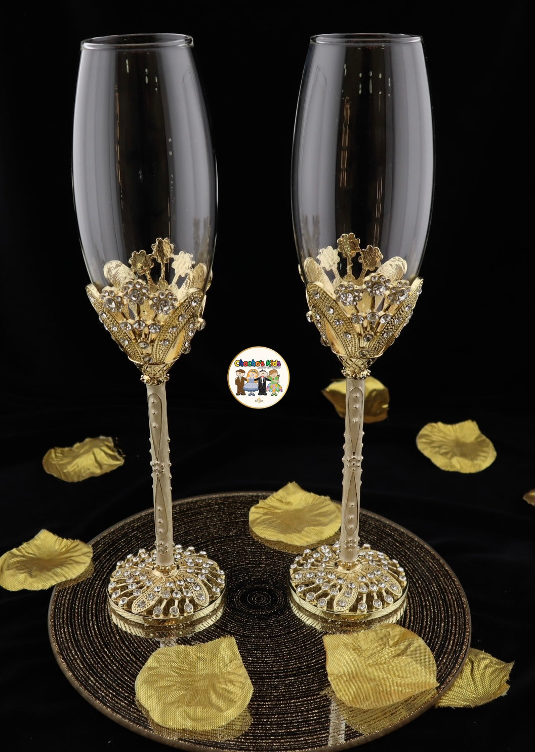 Two ornate Wedding champagne flutes with gold detailing on a black background.