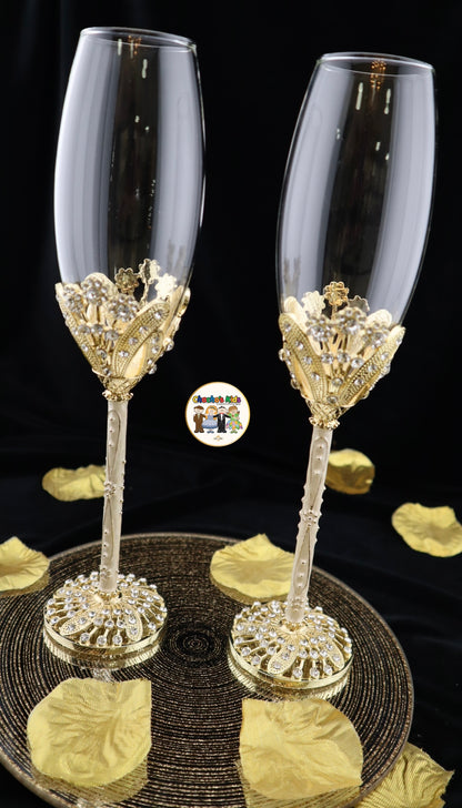 Two ornate Wedding champagne flutes with gold and crystal detailing on a black background.