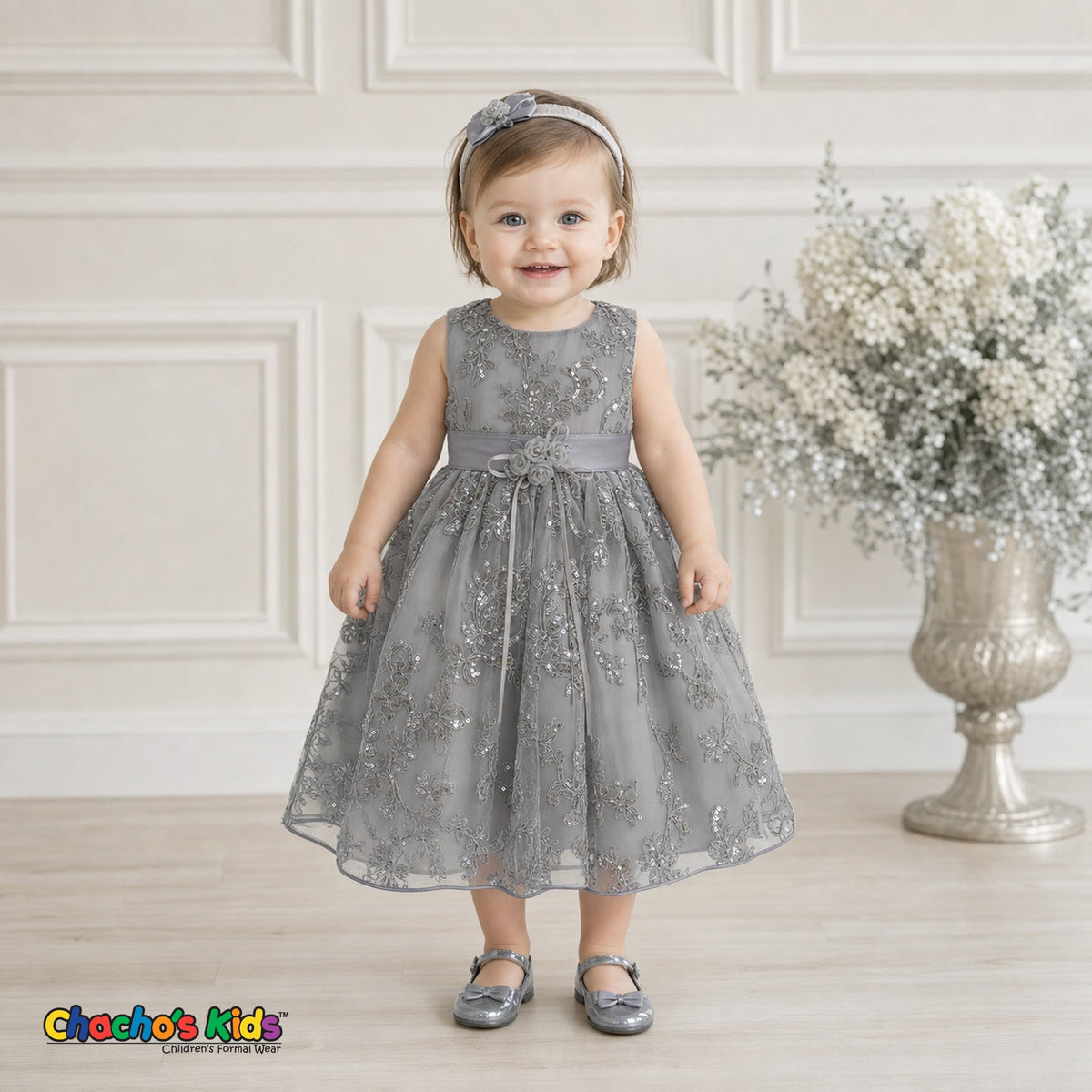 Baby girl wearing silver embroidered sequin flower girl dress with floral waist detail, style 1597