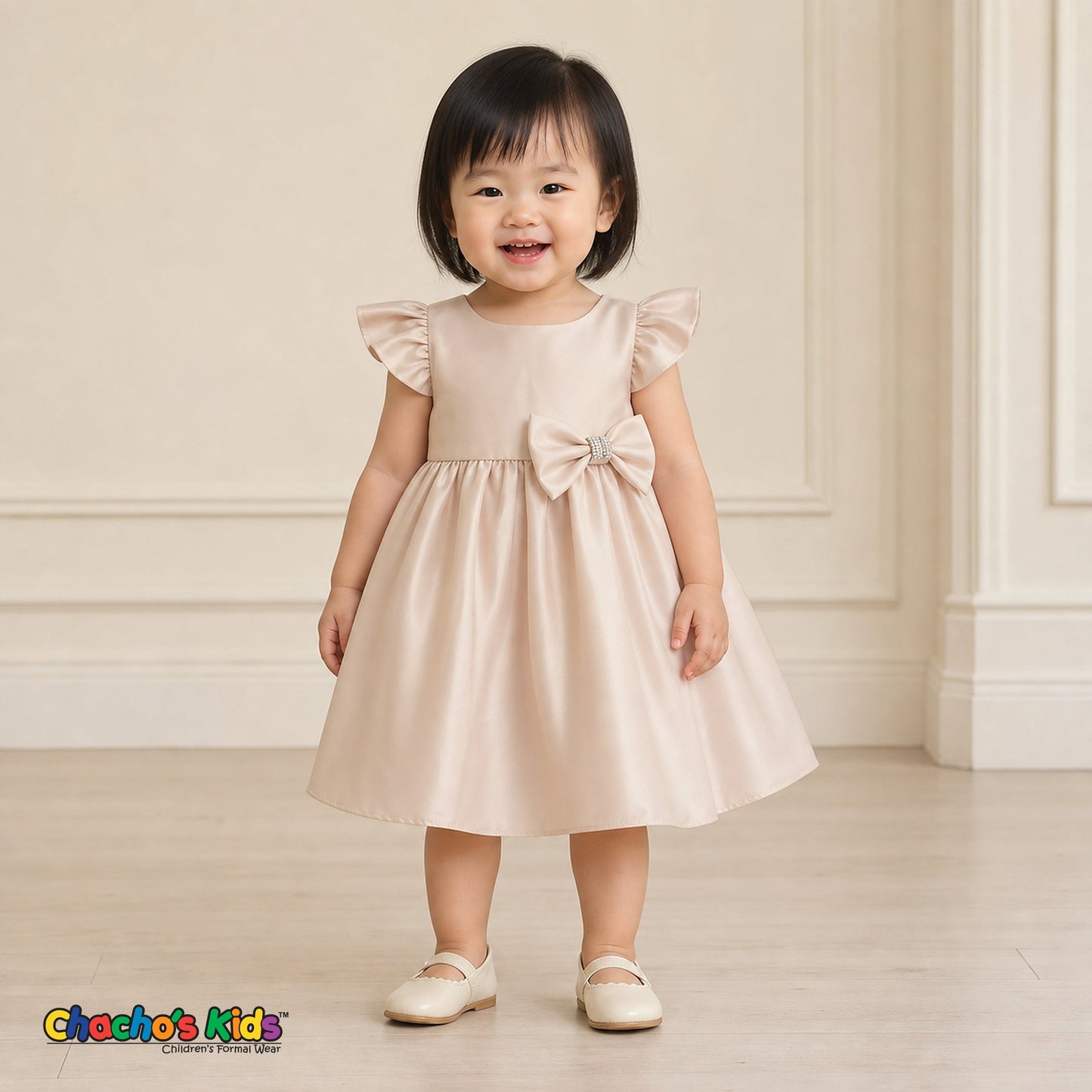 Baby girl wearing champagne satin flower girl dress with flutter sleeves and bow, style B263