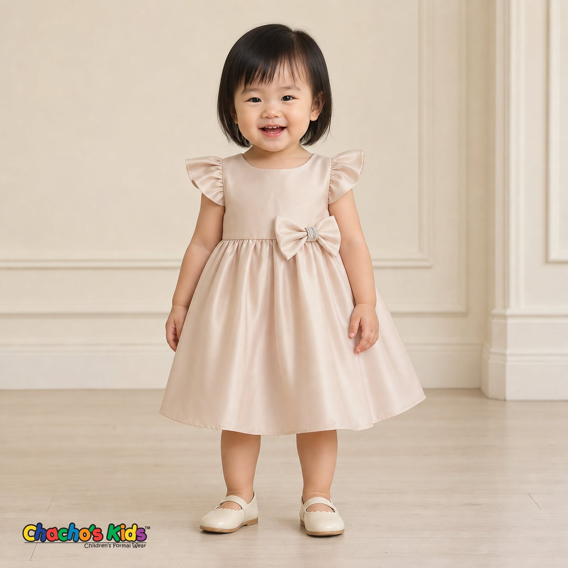 Baby girl wearing champagne satin flower girl dress with flutter sleeves and bow, style B263