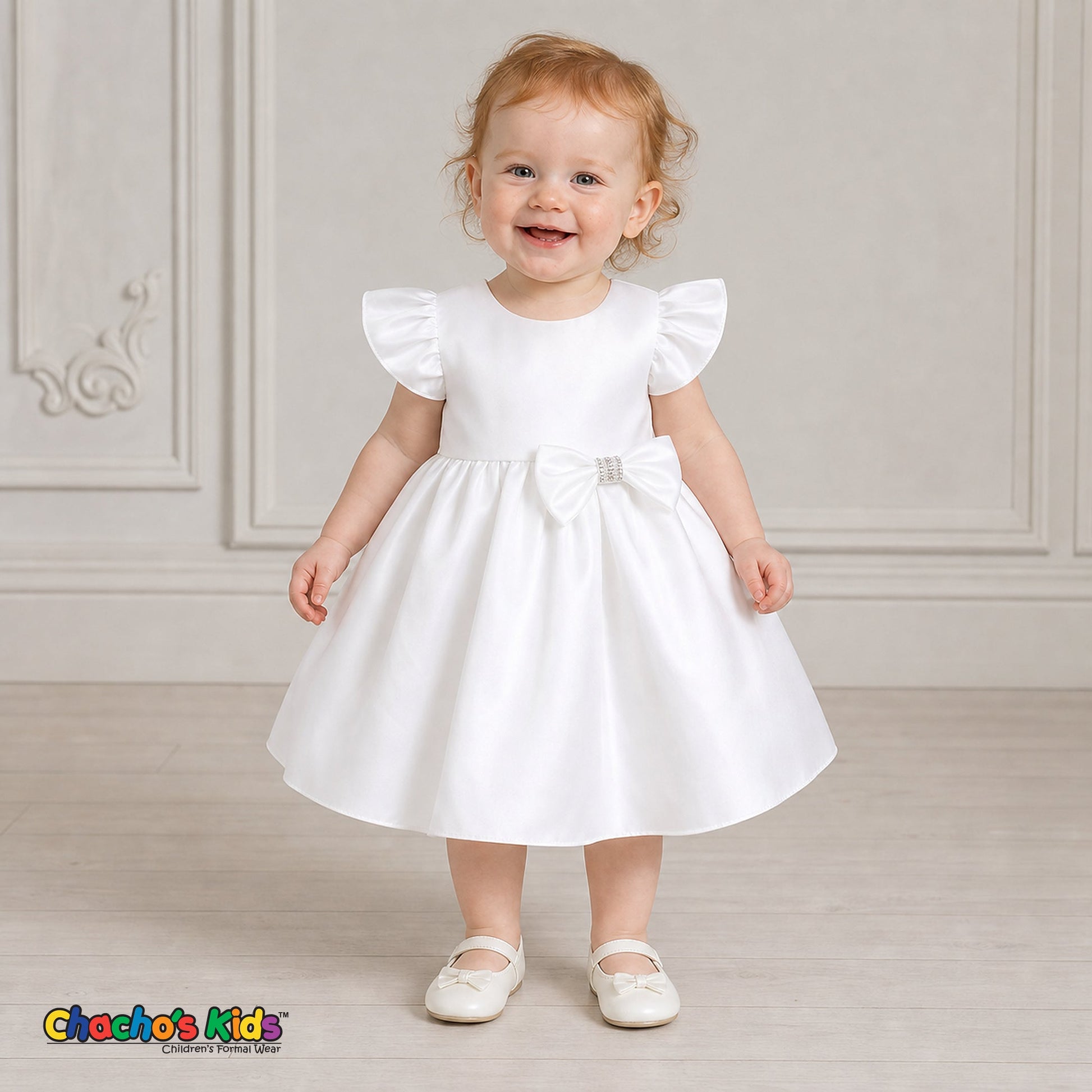 Baby girl wearing white satin flower girl dress with flutter sleeves and bow, style B263