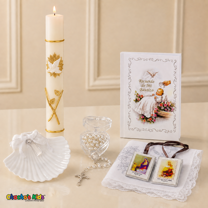 White six-piece Spanish baptism set displayed upright with a lit gold-detailed candle, prayer book, shell, rosary, scapular and lace-edged handkerchief.