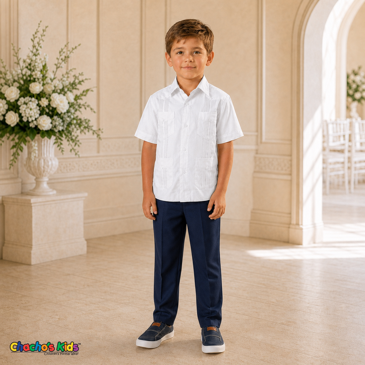 Young boy wearing white 100% linen classic guayabera with four pockets and navy dress trousers, full view