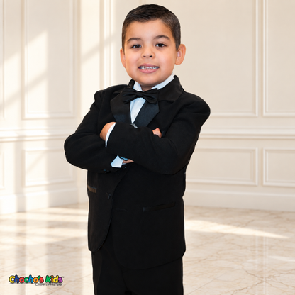 Boys Signature Tuxedo in Black (BY010), child model close-up with arms crossed, showing satin lapels, black bow tie and white shirt.