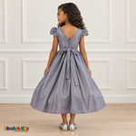 Back view of a girl wearing the lilac shimmer puff sleeve party dress, Style 444, showing the V-shaped back, zipper and tied sash bow.