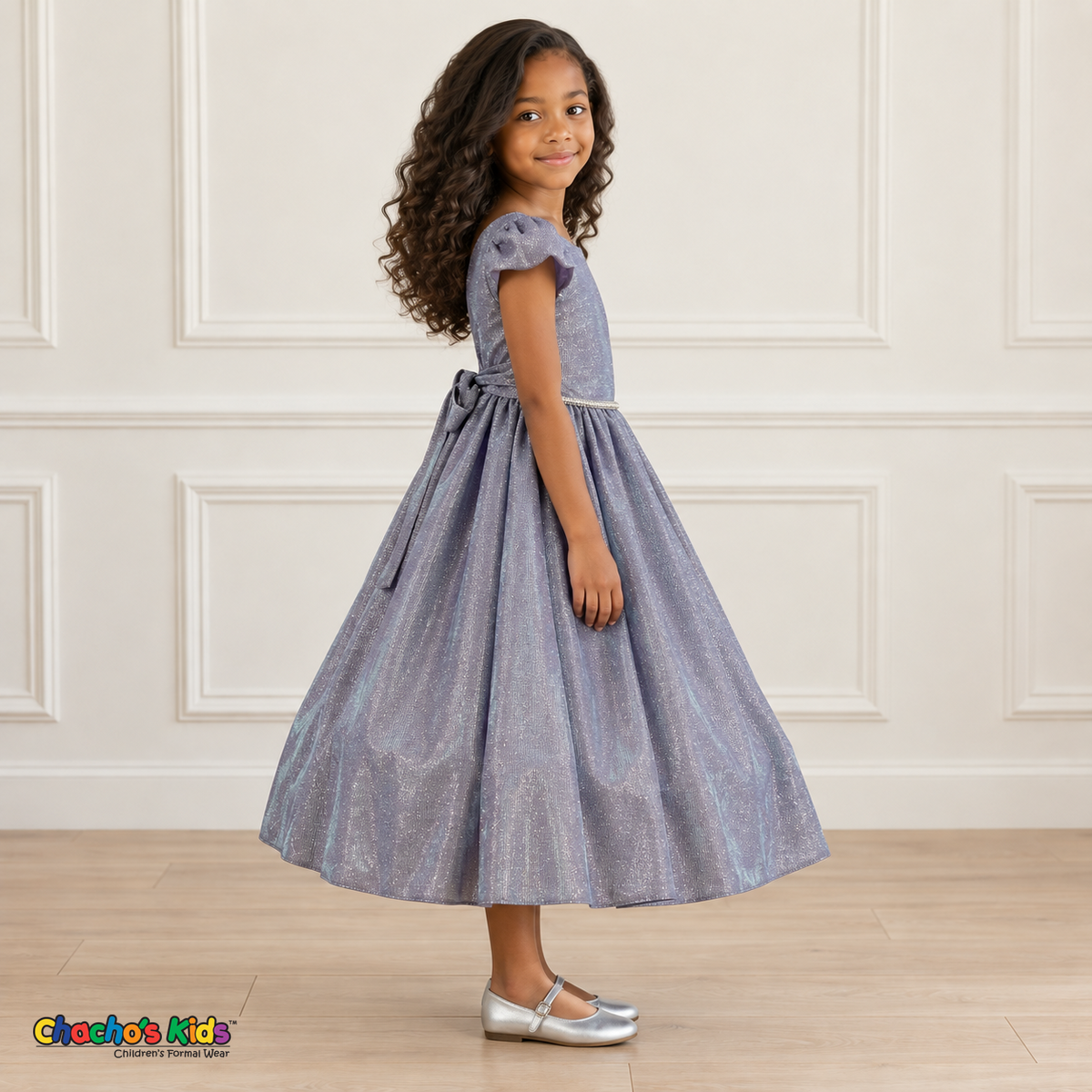 Side view of a girl wearing the lilac shimmer puff sleeve party dress, Style 444, showing the gathered skirt and matching back sash.