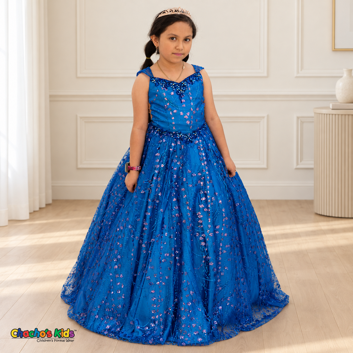 Girl wearing the Royal Blue Glitter Sweetheart Ball Gown (8007), showing its iridescent floral sequins and full floor-length skirt.