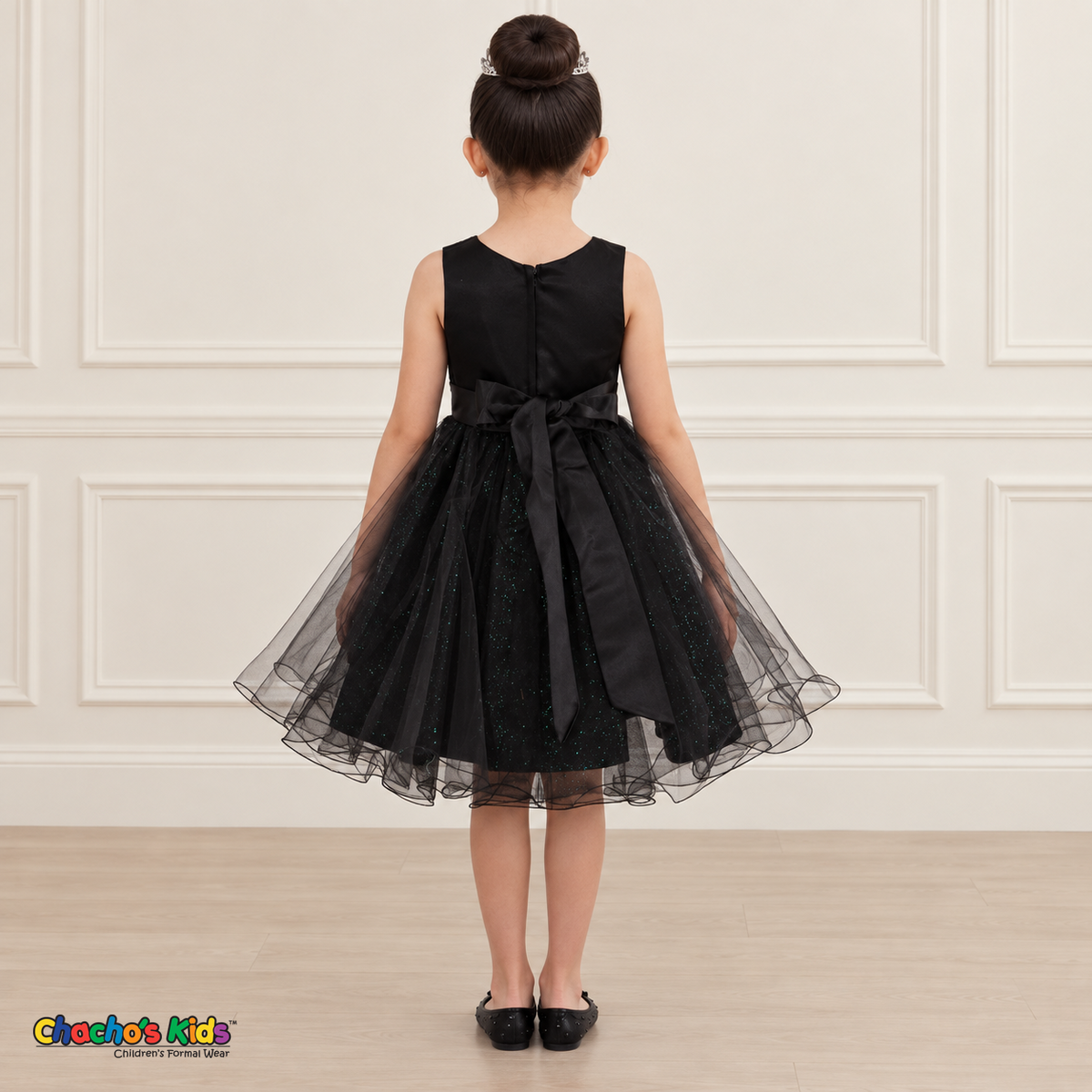 Back view of the black Style 9150 tulle dress on a girl, showing the zipper, matching satin bow, and layered curled hem.