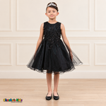 Front view of a girl wearing the black Style 9150 butterfly embroidered tulle dress with pearl accents and a curled hem.