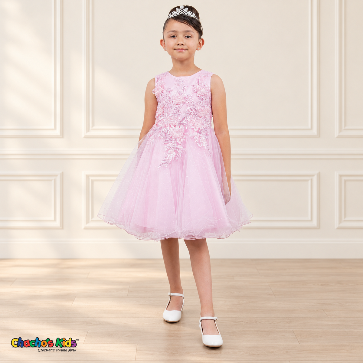 Front view of a girl wearing the pink Style 9150 butterfly embroidered tulle dress with pearl accents and a curled hem.