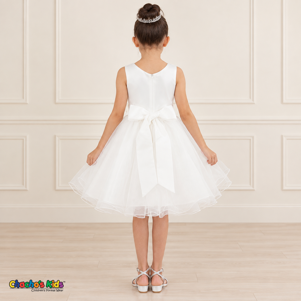 Back view of the white Style 9150 tulle dress on a girl, showing the zipper, matching satin bow, and layered curled hem.