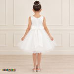 Back view of the white Style 9150 tulle dress on a girl, showing the zipper, matching satin bow, and layered curled hem.
