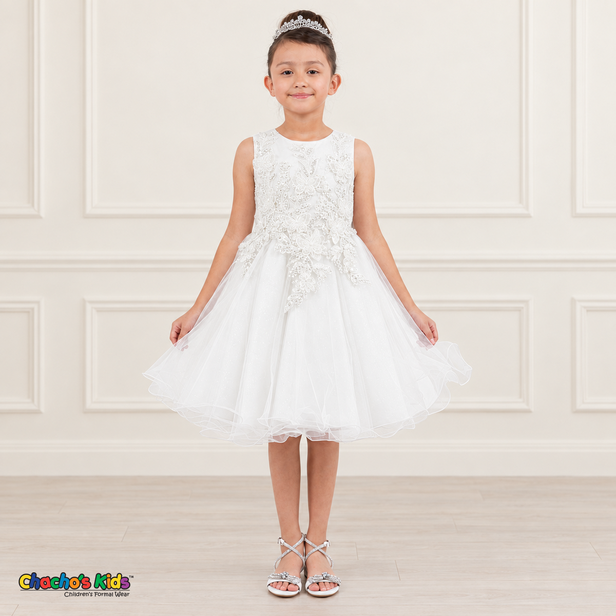 Front view of a girl wearing the white Style 9150 butterfly embroidered tulle dress with pearl accents and a curled hem.