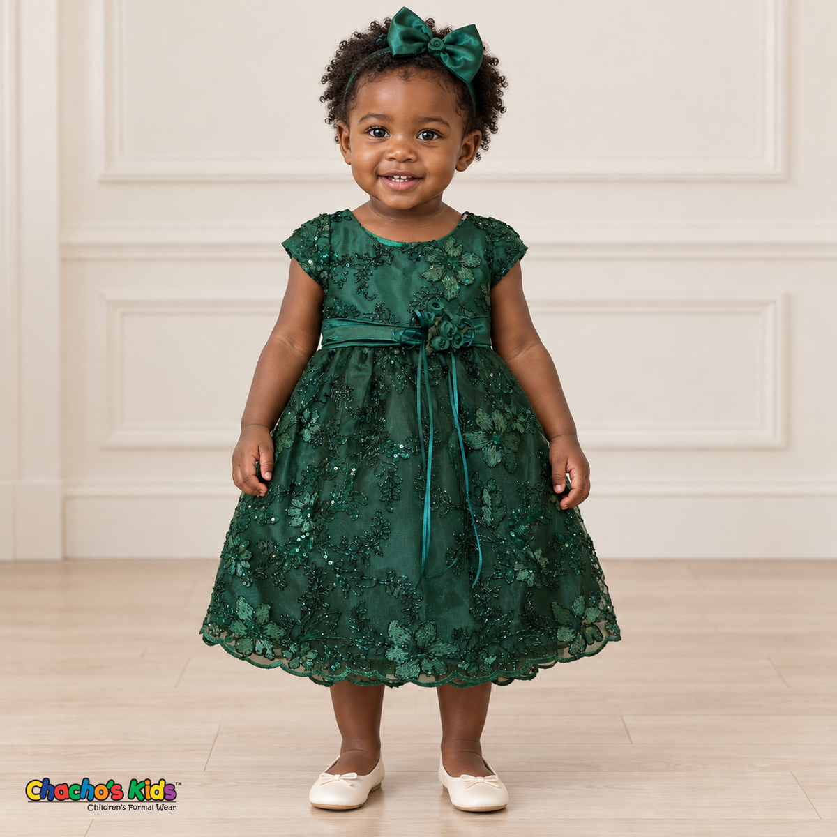 Baby girl wearing the Emerald Green Baby Floral Rosette Dress D-1664, front view with matching bow headband.
