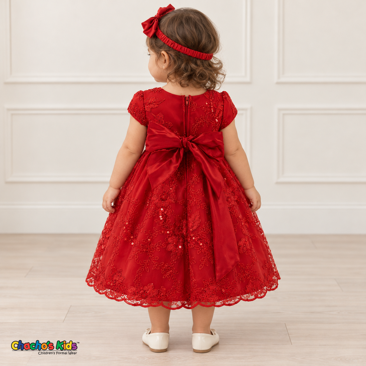Baby girl wearing the Red Baby Floral Rosette Dress D-1664, back view with satin bow and zipper.