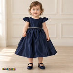 Front view of a baby girl wearing the Navy Blue Baby Satin Puff Sleeve Party Dress (B266), with rounded puff sleeves, a jeweled waistband and a full satin skirt.