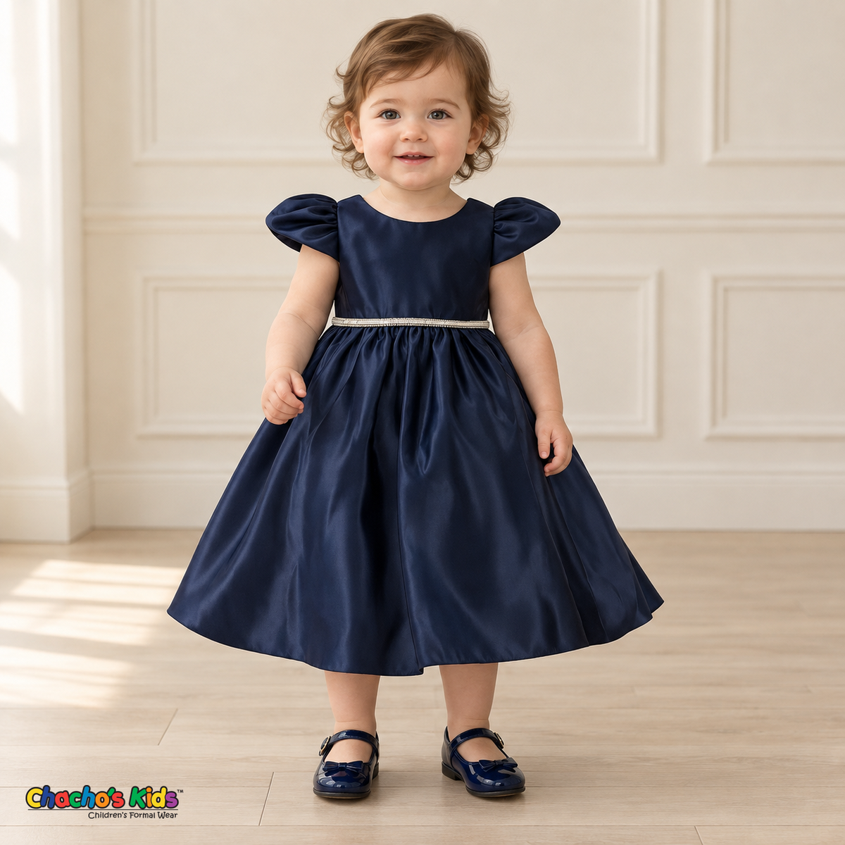 Front view of a baby girl wearing the Navy Blue Baby Satin Puff Sleeve Party Dress (B266), with rounded puff sleeves, a jeweled waistband and a full satin skirt.
