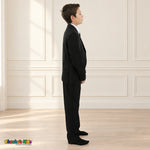Black BJ4005 Executive boys suit on the existing child model, right side view showing the tailored coat, sleeve buttons and matching trousers.