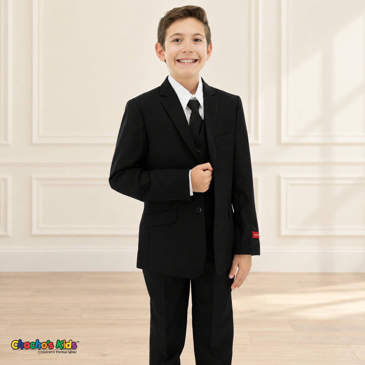 Black BJ4005 Executive boys suit on the existing child model, front detail view showing the notched lapels, button closure, pockets, white shirt and black tie.