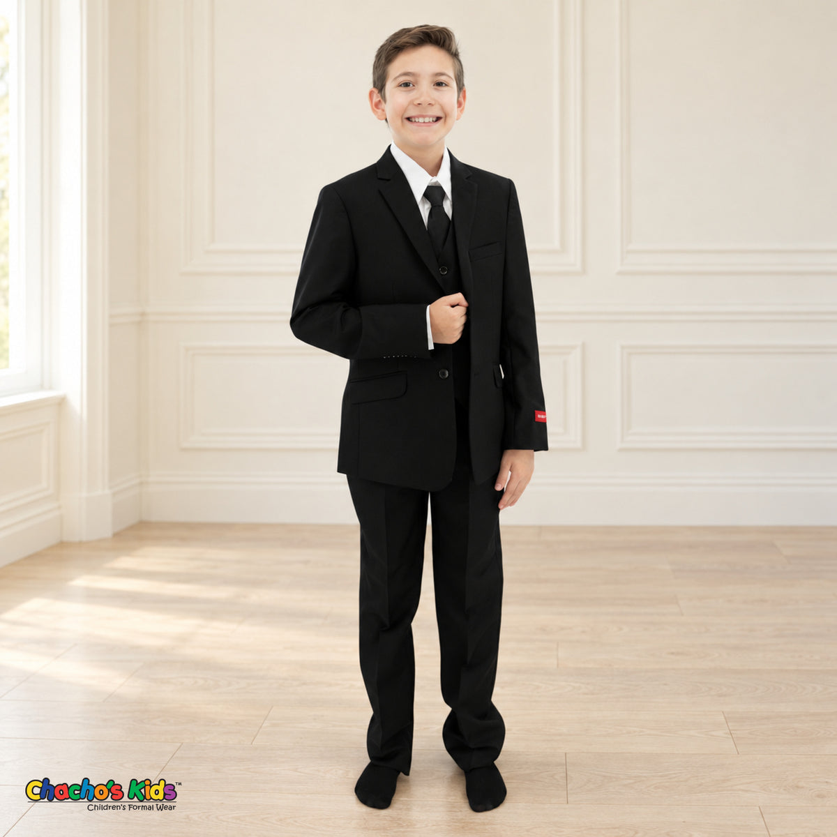 Black BJ4005 Executive boys suit on the existing child model, full front view showing the notched-lapel coat, white shirt, black tie and matching trousers.
