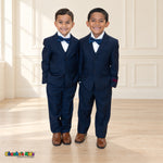 Two boys wearing navy blue BJ4005 suits with white shirts, blue satin bow ties and brown dress shoes.