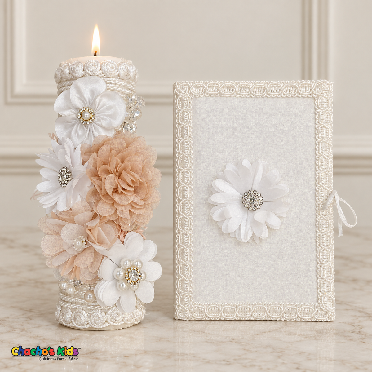 Lit champagne and white floral baptism candle beside the plain white Bible with a single white flower.