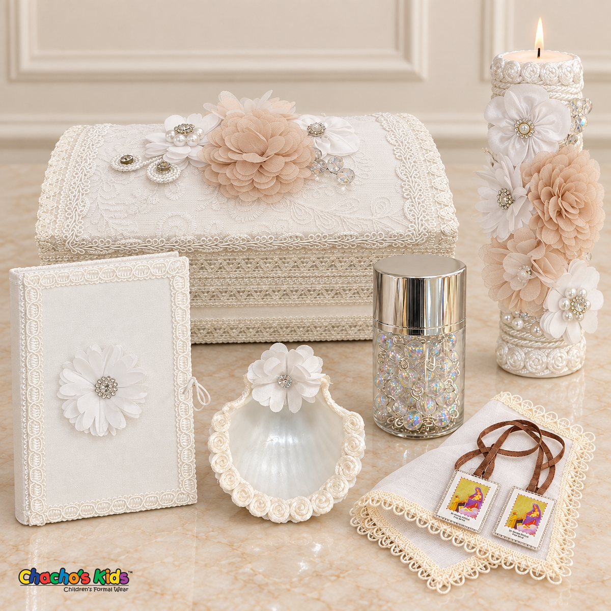 Seven-piece champagne and white floral baptism set with long keepsake chest, lit candle, white Bible, shell, rosary jar, white handkerchief and visible scapular.