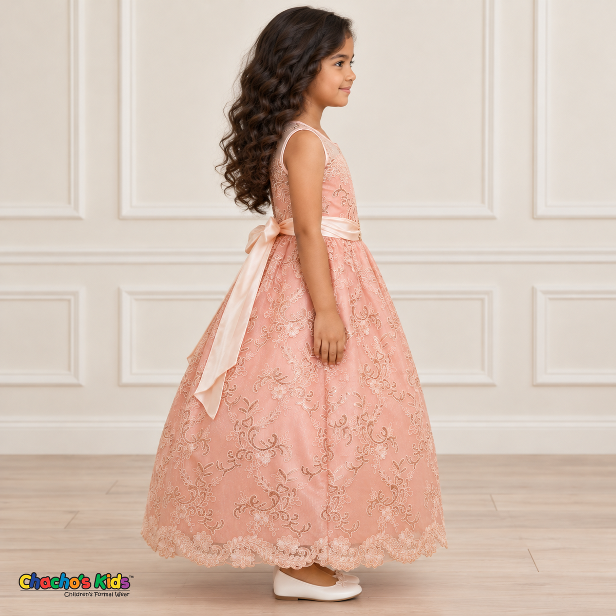 Girl wearing the Blush Floral Embroidered Dress, Style D1550, side view, showing the sleeveless silhouette, floral embroidery and scalloped skirt.