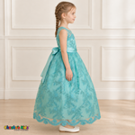 Girl wearing the Mint Green Floral Embroidered Dress, Style D1550, side view, showing the sleeveless silhouette, floral embroidery and scalloped skirt.