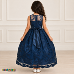 Girl wearing the Navy Blue Floral Embroidered Dress, Style D1550, back view, showing the embroidered sheer back, zipper and satin bow.