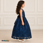 Girl wearing the Navy Blue Floral Embroidered Dress, Style D1550, side view, showing the sleeveless silhouette, floral embroidery and scalloped skirt.