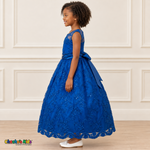 Girl wearing the Royal Blue Floral Embroidered Dress, Style D1550, side view, showing the sleeveless silhouette, floral embroidery and scalloped skirt.