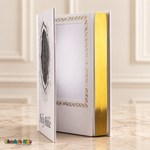Large English Holy Bible with white cover and gold details — open view showing the interior photo pocket and reflective page edges