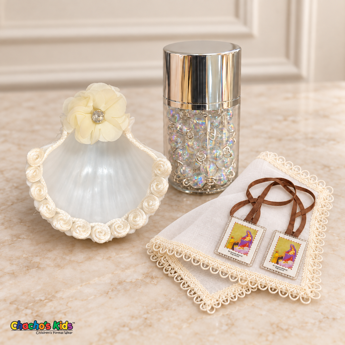 Ivory floral baptism shell, ivory handkerchief, iridescent rosary in a silver-lidded jar and visible brown-ribbon scapular.
