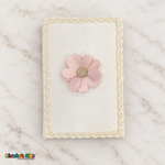 Ivory baptism Bible with blush pink flower and ivory braided edging.