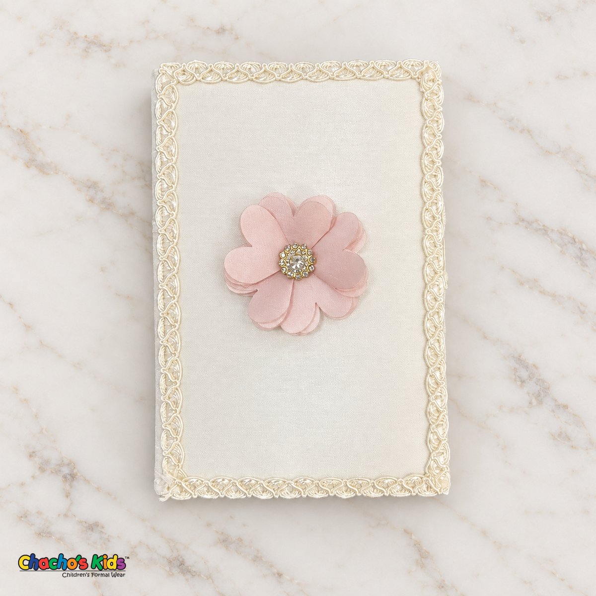Ivory baptism Bible with blush pink flower and ivory braided edging.