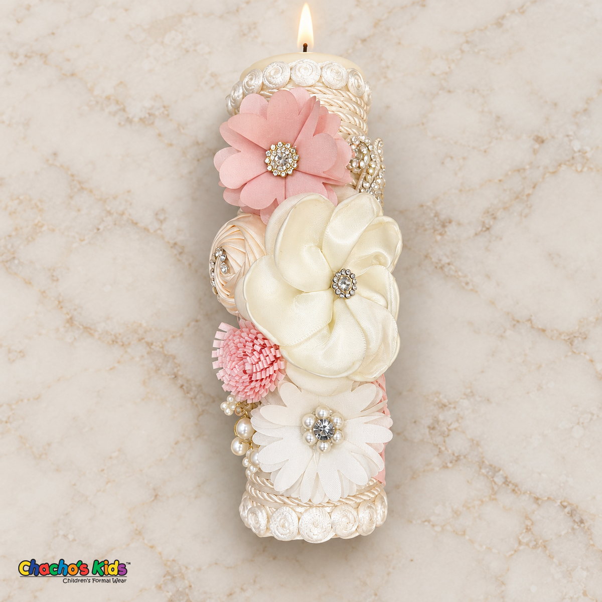 Full-length lit ivory baptism candle with blush pink and ivory flowers, pearls and rhinestone details.